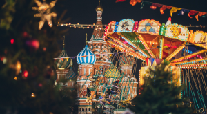 Christmas market with festive architecure and swinging chair ride adorned with colourful lights 